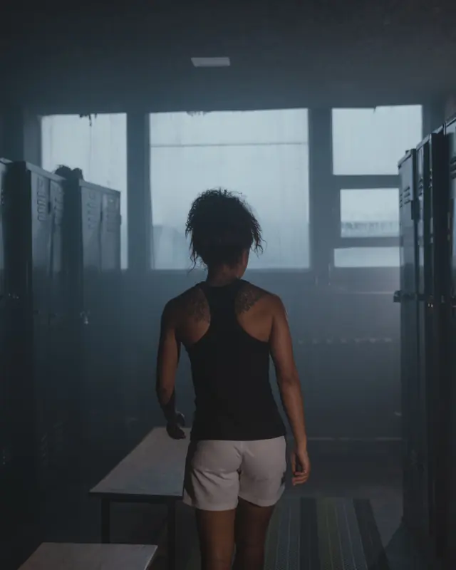 A woman alone in an empty gym locker room before training